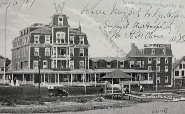A historic, black and white photo depicting a large hotel. A large "W" sit atop the hotel.