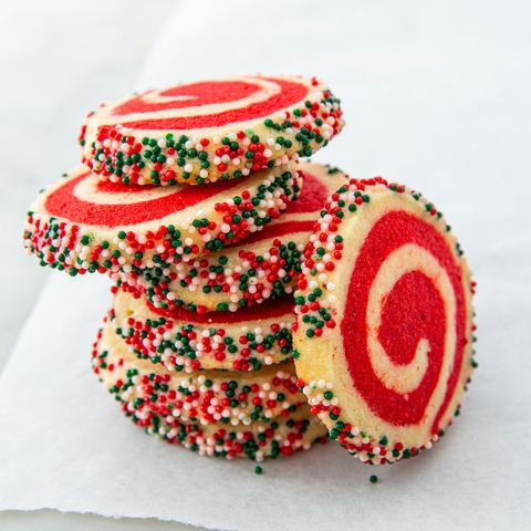 a plate of six cookies. White and red-swirled cookies, with sprinkles on the edges.