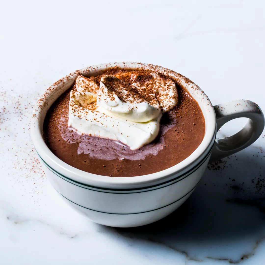 A mug of hot cocoa, with whip cream on top.