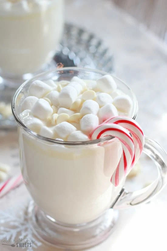 white hot chocolate in glass mug with candy canes