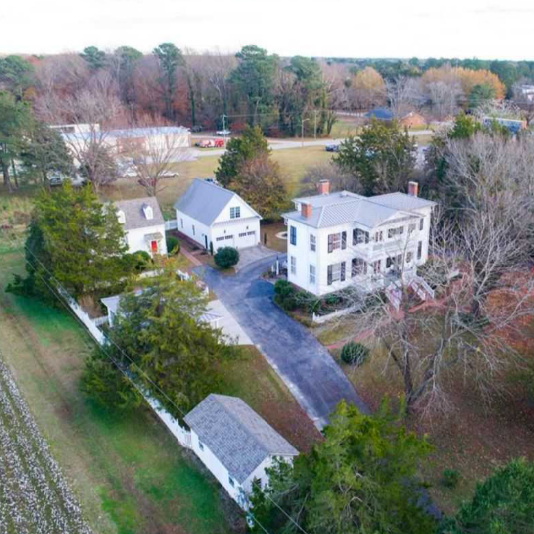 An overhead view of a grand, large home. It is fall; trees have lost leaves.
